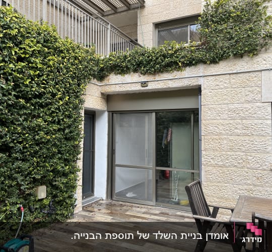 מרפסת עם דלת זכוכית, שולחן וכיסאות עץ